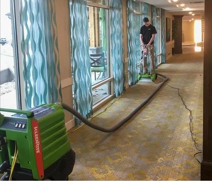 man drying carpet in hotel with SERVPRO equiptment